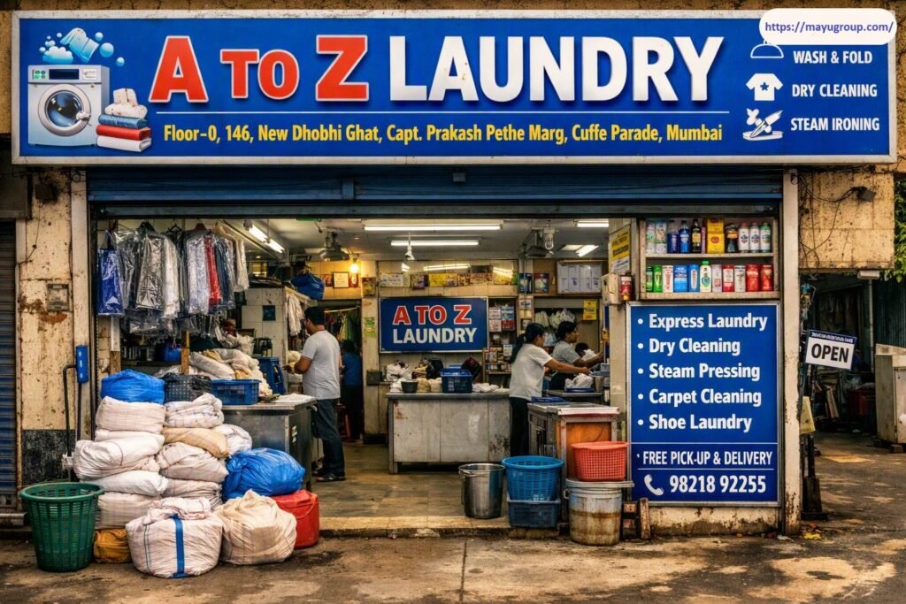 Storefront view of A TO Z LAUNDRY located at New Dhobhi Ghat in Cuffe Parade, Mumbai, showing stacked laundry sacks, hung dry-cleaned clothing, service display boards listing express laundry and steam pressing, and staff working inside the shop entrance.